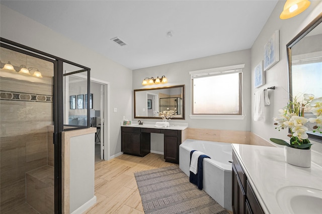 full bathroom with visible vents, two vanities, a sink, a shower stall, and a garden tub