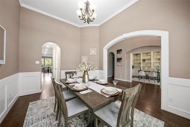 dining space featuring an inviting chandelier, dark wood-style floors, arched walkways, and ornamental molding