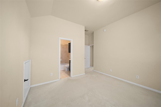 unfurnished bedroom featuring visible vents, lofted ceiling, ensuite bath, baseboards, and light colored carpet