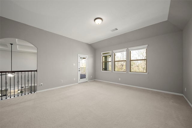 empty room with vaulted ceiling, baseboards, visible vents, and light carpet