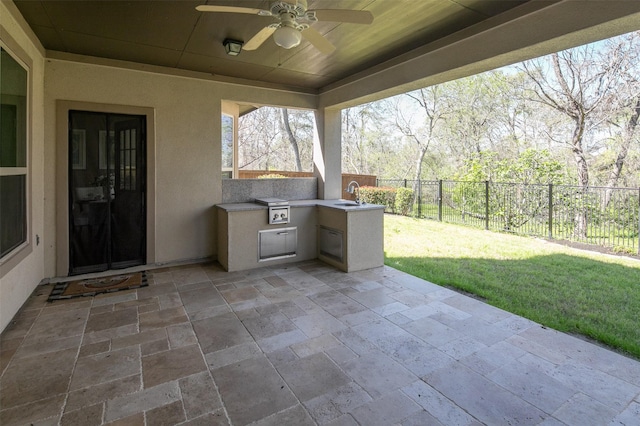 view of patio with a ceiling fan, fence, area for grilling, a sink, and grilling area