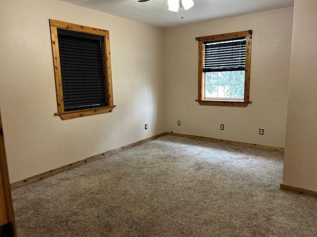 spare room with a ceiling fan, baseboards, and carpet floors