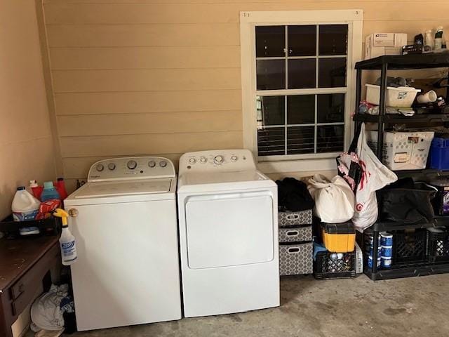 laundry room featuring laundry area, washing machine and dryer, and wood walls