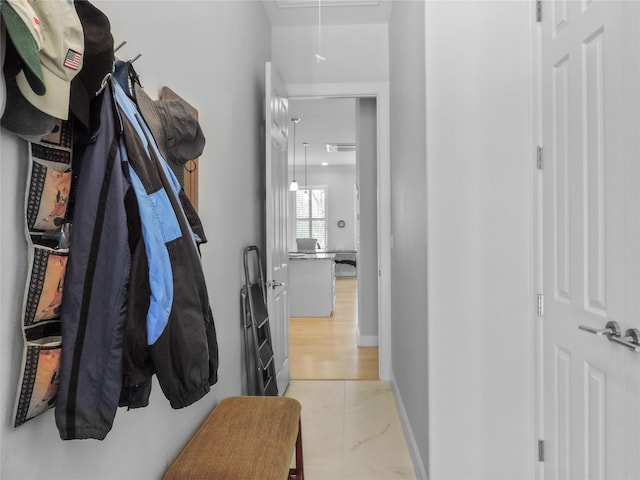 hallway with attic access, marble finish floor, and visible vents
