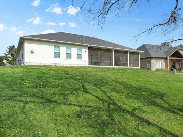 back of house with a sunroom, a lawn, and stucco siding