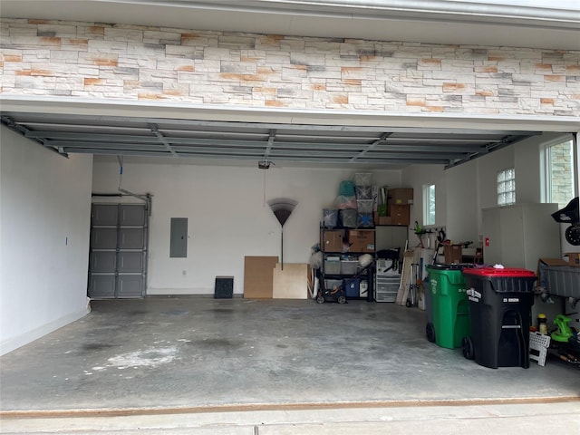 garage featuring electric panel and baseboards