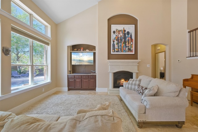 5206 Briarwick Meadow Ln, Sugar Land, TX 77479 - living room with high vaulted ceiling, a glass covered fireplace, arched walkways, and baseboards