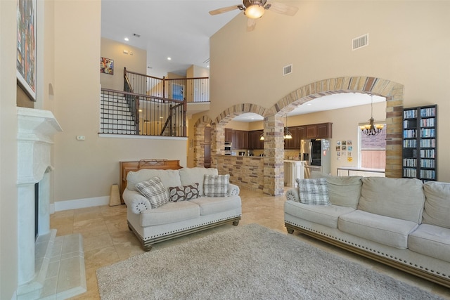 5206 Briarwick Meadow Ln, Sugar Land, TX 77479 - living room with arched walkways, a ceiling fan, a high ceiling, a chandelier, and stairway
