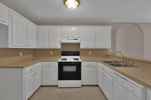 kitchen with white appliances, light tile patterned floors, a sink, white cabinets, and under cabinet range hood