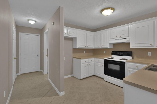 kitchen featuring under cabinet range hood, white cabinetry, range with electric stovetop, and light tile patterned floors