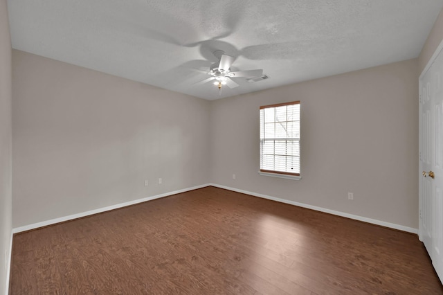 spare room with visible vents, baseboards, dark wood-style floors, a textured ceiling, and a ceiling fan