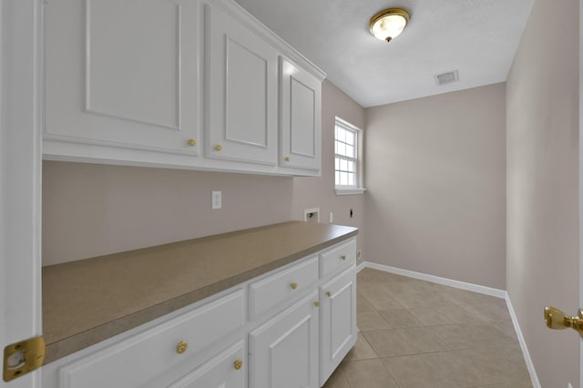 1015 Chickasaw Dr, Montgomery, TX 77316 - kitchen featuring white cabinetry and light tile patterned floors