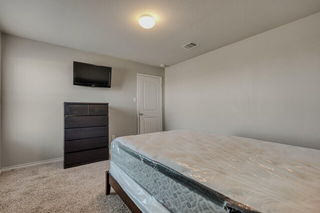 carpeted bedroom featuring baseboards and visible vents