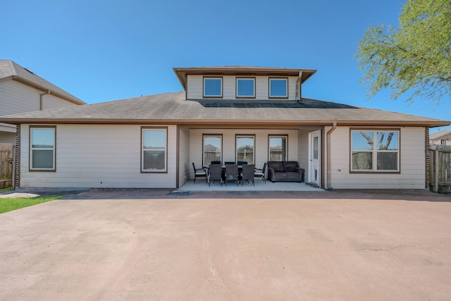 rear view of house featuring fence, roof with shingles, and a patio area