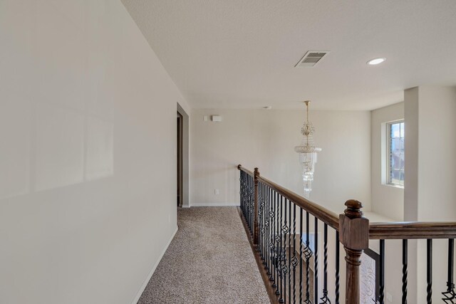 hall featuring visible vents, an upstairs landing, recessed lighting, carpet floors, and baseboards