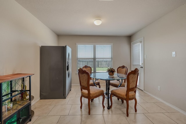dining area featuring light tile patterned floors and baseboards