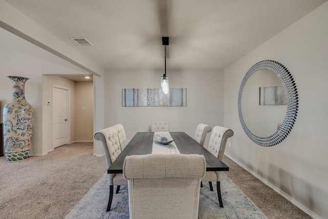 carpeted dining room featuring visible vents and baseboards