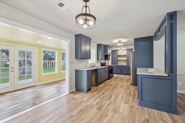 203 N 21st St, Nederland, TX 77627 - kitchen with light countertops, gas range oven, and light wood finished floors