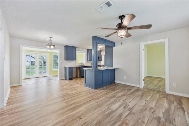 203 N 21st St, Nederland, TX 77627 - kitchen featuring a peninsula, light wood-style flooring, baseboards, a ceiling fan, and a sink