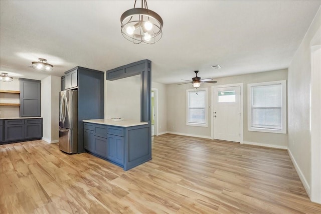203 N 21st St, Nederland, TX 77627 - kitchen featuring freestanding refrigerator, baseboards, light wood finished floors, ceiling fan, and light countertops