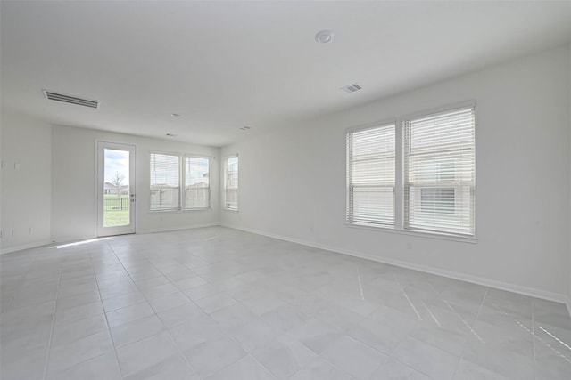 unfurnished room with baseboards, light tile patterned flooring, and visible vents