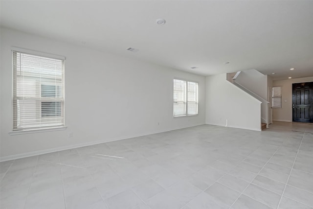 unfurnished living room featuring stairs, recessed lighting, and baseboards
