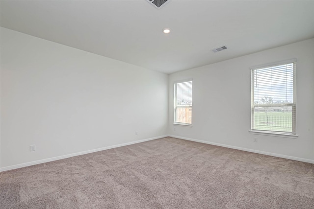 empty room with baseboards, carpet flooring, recessed lighting, and visible vents