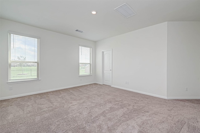 spare room with carpet floors, plenty of natural light, and visible vents