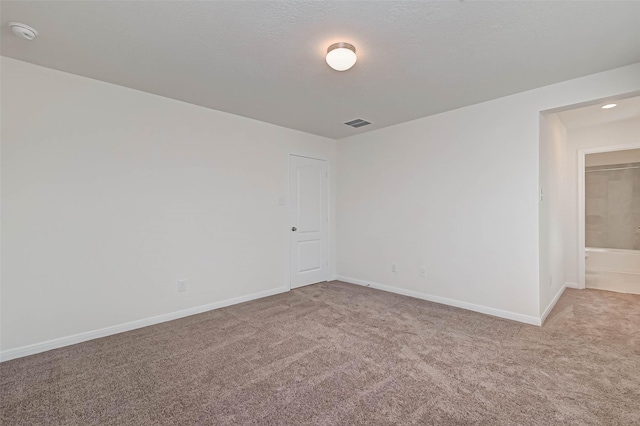 spare room featuring baseboards, carpet, and visible vents