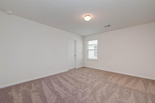 unfurnished room featuring light colored carpet, baseboards, and visible vents