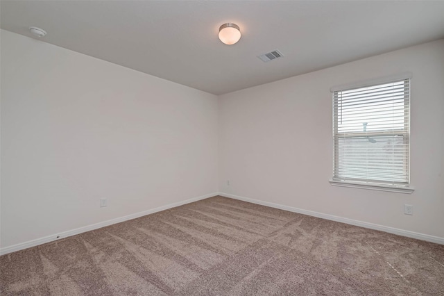 carpeted spare room with baseboards and visible vents