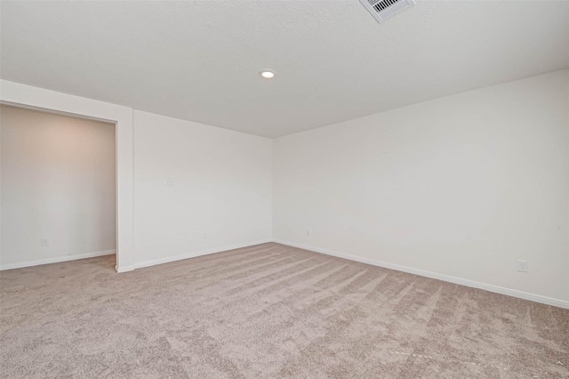 spare room with baseboards, carpet, recessed lighting, and visible vents