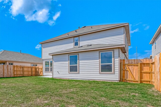 back of property featuring a fenced backyard, a gate, and a yard