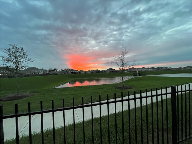property view of water featuring fence and a residential view