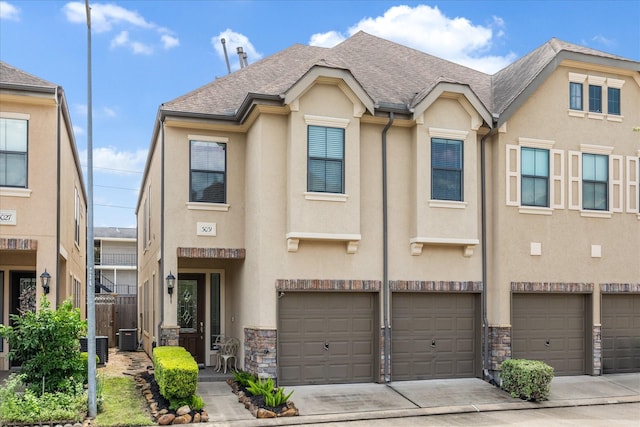 3031 Royal Oaks Grv, Houston, TX 77082 - view of property featuring stone siding, stucco siding, an attached garage, central AC, and driveway