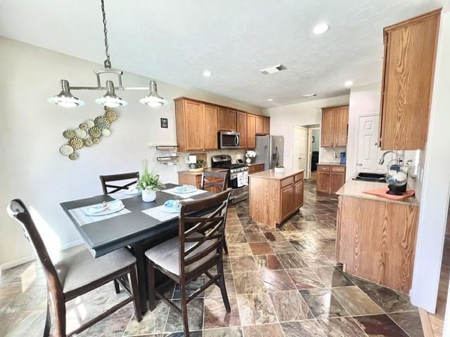 dining room with stone finish floor, recessed lighting, and visible vents