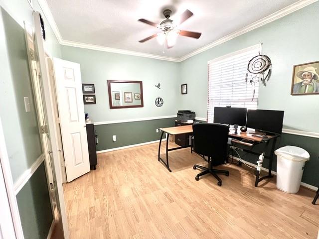 office space featuring crown molding, a ceiling fan, baseboards, and light wood-type flooring