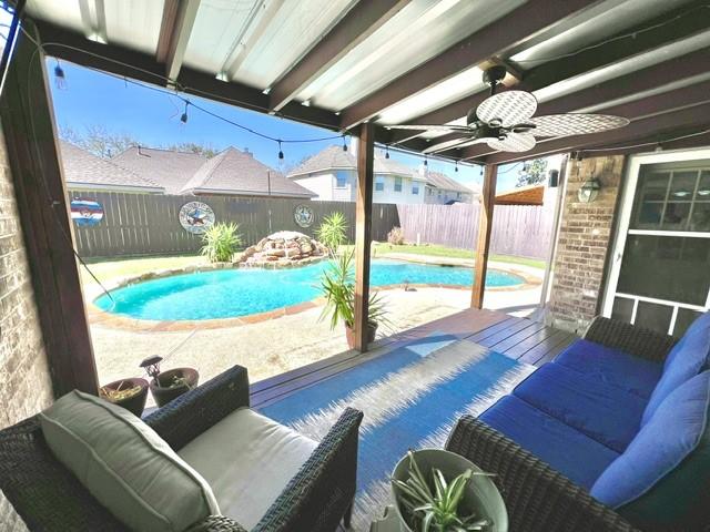 view of pool featuring a fenced in pool, a fenced backyard, a ceiling fan, and a patio area