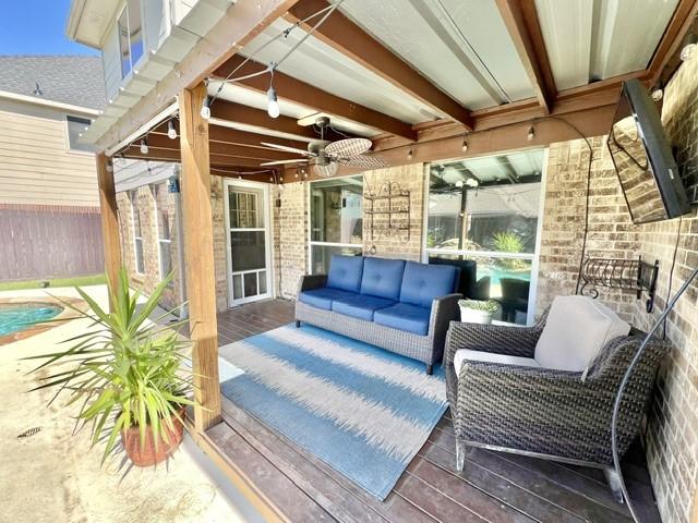exterior space with ceiling fan, fence, and an outdoor hangout area
