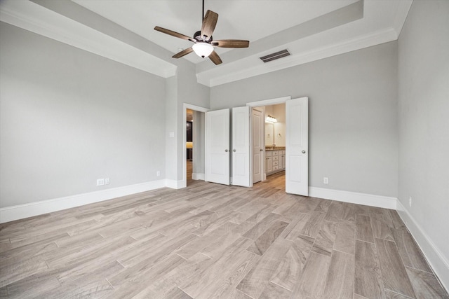 unfurnished bedroom featuring visible vents, ensuite bathroom, light wood-style floors, baseboards, and ceiling fan