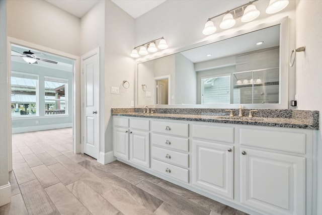 bathroom featuring a healthy amount of sunlight, a stall shower, and a sink