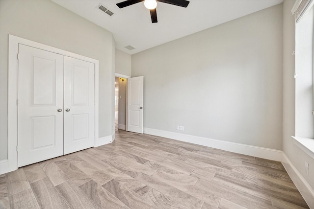 unfurnished bedroom with a closet, visible vents, a ceiling fan, and baseboards