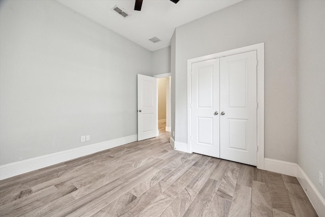 unfurnished bedroom with visible vents, baseboards, light wood-style floors, and a closet