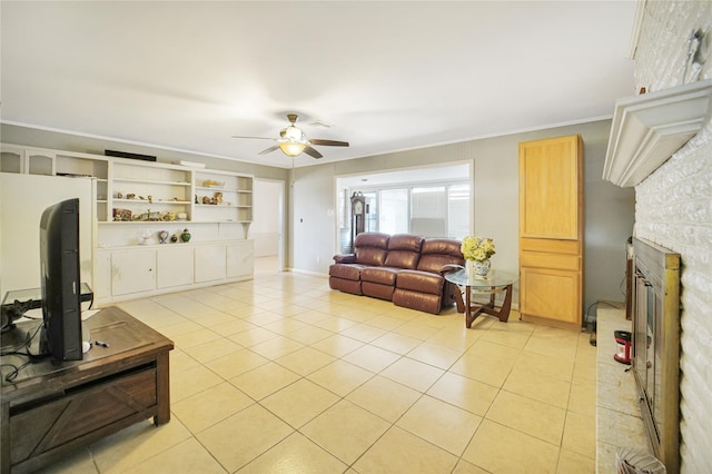 living area with crown molding, light tile patterned floors, a fireplace, and ceiling fan