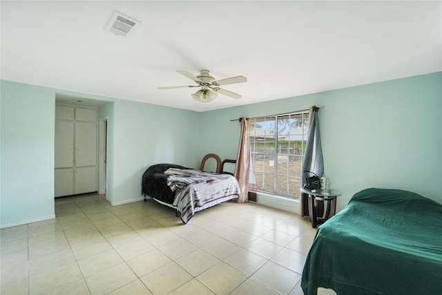 bedroom featuring ceiling fan, visible vents, baseboards, and light tile patterned flooring