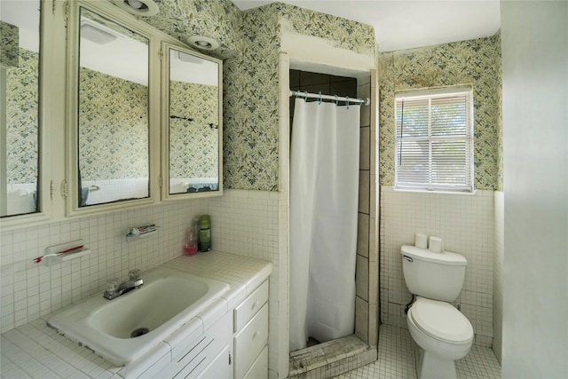 full bath featuring vanity, a shower with shower curtain, tile patterned flooring, tile walls, and toilet
