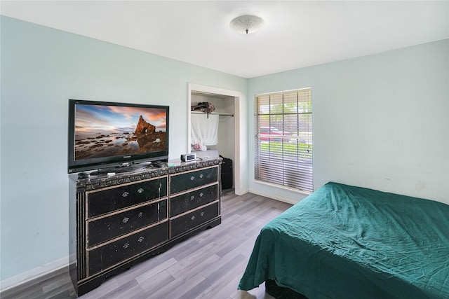 bedroom featuring a closet, baseboards, and wood finished floors