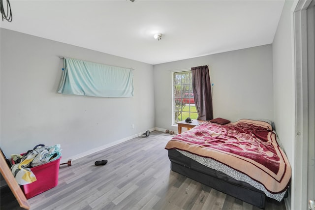 bedroom featuring wood finished floors and baseboards