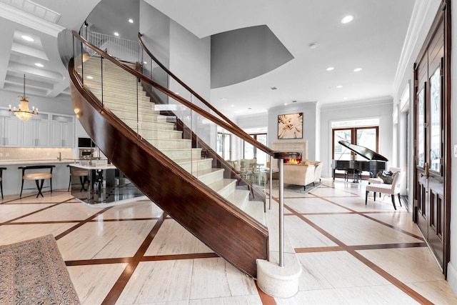 2247 Bartlett St, Houston, TX 77098 - staircase featuring inlaid floor details, crown molding, recessed lighting, and a warm lit fireplace