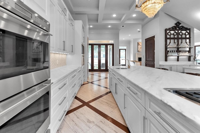 2247 Bartlett St, Houston, TX 77098 - kitchen featuring double oven, a sink, recessed lighting, white cabinetry, and tasteful backsplash